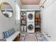 Cozy laundry room with stacked washer/dryer, ample storage shelves with baskets, and unique patterned tile flooring at 300 Tarragon Dr, Fayetteville, GA 30215