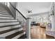 Open-concept living room with stairs leading up, featuring hardwood floors and abundant natural light through large windows at 300 Tarragon Dr, Fayetteville, GA 30215
