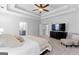 Large bedroom with ceiling fan, dresser with TV, seating, and doorway to the main bath at 300 Tarragon Dr, Fayetteville, GA 30215