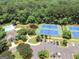 Aerial view of a community pool, tennis courts, mature trees, parking and a clubhouse at 300 Tarragon Dr, Fayetteville, GA 30215