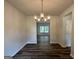 Dining area features hardwood floors, a modern chandelier, and large window for natural light at 1102 Campbell Rd # 01, Covington, GA 30014