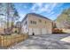 Spacious backyard with multiple garage doors, a well-manicured lawn and mature trees at 140 Rockglen Ct, Fayetteville, GA 30215