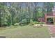 Expansive backyard featuring a deck, manicured lawn, and wooded surroundings at 140 Rockglen Ct, Fayetteville, GA 30215