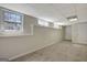 A spacious basement with carpet, featuring several windows and a door, offering potential for various uses and customization at 140 Rockglen Ct, Fayetteville, GA 30215