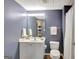 A bathroom featuring a white vanity and a matching toilet, complemented by a mirror and a shower with a white curtain at 140 Rockglen Ct, Fayetteville, GA 30215
