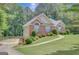 Well-kept exterior with brick accents, complemented by a lush green lawn and mature trees at 140 Rockglen Ct, Fayetteville, GA 30215