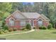 Charming brick home with a well-manicured lawn, blue shutters, and beautiful landscaping at 140 Rockglen Ct, Fayetteville, GA 30215