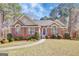 Charming brick home with a manicured lawn, complemented by lush greenery and inviting curb appeal at 140 Rockglen Ct, Fayetteville, GA 30215