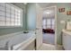 Soaking tub in the main bathroom with a glass block window and doorway to the main bedroom at 140 Rockglen Ct, Fayetteville, GA 30215