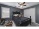 Bedroom features a dark accent wall, a five-blade ceiling fan, and a view of the outside at 149 Crown Glen Way, Stockbridge, GA 30281