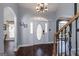Elegant foyer with dark wood floors, a white front door with decorative glass, and staircase with wooden railing at 149 Crown Glen Way, Stockbridge, GA 30281