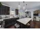 Open kitchen and living space with island seating, stainless appliances, and dark cabinets at 149 Crown Glen Way, Stockbridge, GA 30281