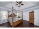 Bedroom suite featuring tray ceiling, hardwood floors, canopy bed, and ample storage at 149 Crown Glen Way, Stockbridge, GA 30281