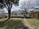 View of a quaint backyard with a tree and a white house with dark trim at 1165 Fair Sw St, Atlanta, GA 30314