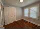 Bedroom featuring hardwood floors, two windows, and a spacious closet at 1165 Fair Sw St, Atlanta, GA 30314