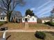 Charming one-story home with a red door, complemented by lush trees and a well-maintained lawn at 1165 Fair Sw St, Atlanta, GA 30314