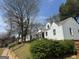 Exterior view of cozy, light-colored homes surrounded by mature trees and green bushes at 1165 Fair Sw St, Atlanta, GA 30314