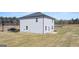A spacious backyard complements this gray home with ample windows, a rear patio, and verdant surroundings at 126 Oakchase Park Lane, Hampton, GA 30228