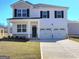 Inviting two-story home with a two-car garage, covered porch, and well-manicured lawn at 126 Oakchase Park Lane, Hampton, GA 30228