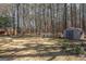 Large grassy backyard featuring mature trees, spring blooms, and an outdoor storage shed at 120 Fountain Head, Peachtree City, GA 30269