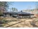 The backyard features a well-maintained lawn, mature trees, with a patio and a screened-in porch at 120 Fountain Head, Peachtree City, GA 30269