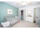 Bedroom with light teal accent wall, gray baby crib and closet at 120 Fountain Head, Peachtree City, GA 30269