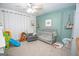 Bedroom with light teal accent wall and a gray baby crib at 120 Fountain Head, Peachtree City, GA 30269