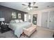 The main bedroom features a ceiling fan, a bench and soft neutral colored carpet and light gray walls at 120 Fountain Head, Peachtree City, GA 30269