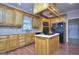 Kitchen featuring an island cooktop, wood cabinetry, and stainless steel appliances at 2808 Autumn Lake Ln # D/6, Decatur, GA 30034