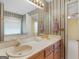Bright bathroom with double vanity, soaking tub under window, and classic striped wallpaper at 230 Acorn Ct, Mcdonough, GA 30253