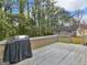 Wooden deck area with grill, railing, and view of wooded backyard with shed at 230 Acorn Ct, Mcdonough, GA 30253