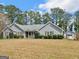 A single-story home with tidy landscaping and a separate garage, all set against a backdrop of tall trees at 230 Acorn Ct, Mcdonough, GA 30253