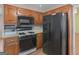 Cozy kitchen with wood cabinets, black appliances, and modern microwave at 230 Acorn Ct, Mcdonough, GA 30253