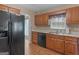 Kitchen featuring wooden cabinets, black appliances, and ample counter space with backyard access at 230 Acorn Ct, Mcdonough, GA 30253