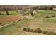 Aerial shot of a sprawling farm with a farmhouse, barn, and fields, highlighting the property's size and layout at 1761 Reavesville Rd, Bowdon, GA 30108