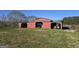 Functional red barn with open bays for equipment storage and workspace, set in a spacious yard at 1761 Reavesville Rd, Bowdon, GA 30108