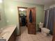 View of an ensuite bathroom, featuring tiled floors, a toilet, and a door leading to the walk-in closet at 1761 Reavesville Rd, Bowdon, GA 30108