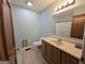 Well-lit bathroom features a wood vanity, tiled floors, and a shower/tub combination with decorative shower curtain at 1761 Reavesville Rd, Bowdon, GA 30108