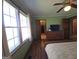 View of a bright bedroom with a large window, hardwood floors, and a wood dresser against the wall at 1761 Reavesville Rd, Bowdon, GA 30108