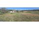 Scenic view of a charming home with dormer windows, surrounded by fields and a tree line at 1761 Reavesville Rd, Bowdon, GA 30108