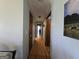 Long hallway with hardwood floors leading to multiple rooms, light blue walls, and a picture on the wall at 1761 Reavesville Rd, Bowdon, GA 30108