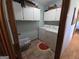 Functional laundry room featuring a washer, dryer, overhead storage cabinets, and a cute watermelon rug at 1761 Reavesville Rd, Bowdon, GA 30108