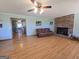 Bright living room with hardwood floors, a brick fireplace, and an open doorway to the kitchen at 1761 Reavesville Rd, Bowdon, GA 30108