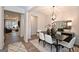 This dining room showcases a modern table and chairs adjacent to an open-concept living space at 10414 Trellis Lane (Lot 36), Hampton, GA 30228