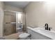 Neutral-toned bathroom features a shower with glass doors, a white toilet, and a sleek, modern vanity at 1190 Plantation Dr, Villa Rica, GA 30180