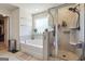 Bathroom featuring soaking tub, glass enclosed shower, and neutral tile surround at 6910 Newcastle Ct, Fairburn, GA 30213