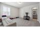 Bright bedroom featuring neutral carpeting and modern furnishings, adjacent to a bathroom at 6910 Newcastle Ct, Fairburn, GA 30213
