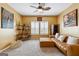 Inviting bedroom featuring a seating area with a brown leather chaise lounge and a ceiling fan at 6910 Newcastle Ct, Fairburn, GA 30213