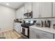 Modern kitchen featuring stainless steel appliances, light gray cabinetry, quartz countertops, and subway tile backsplash at 6910 Newcastle Ct, Fairburn, GA 30213