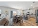 Kitchen and dining area with stainless appliances, a central island, and stylish barstools, offering a cohesive and modern design at 6910 Newcastle Ct, Fairburn, GA 30213